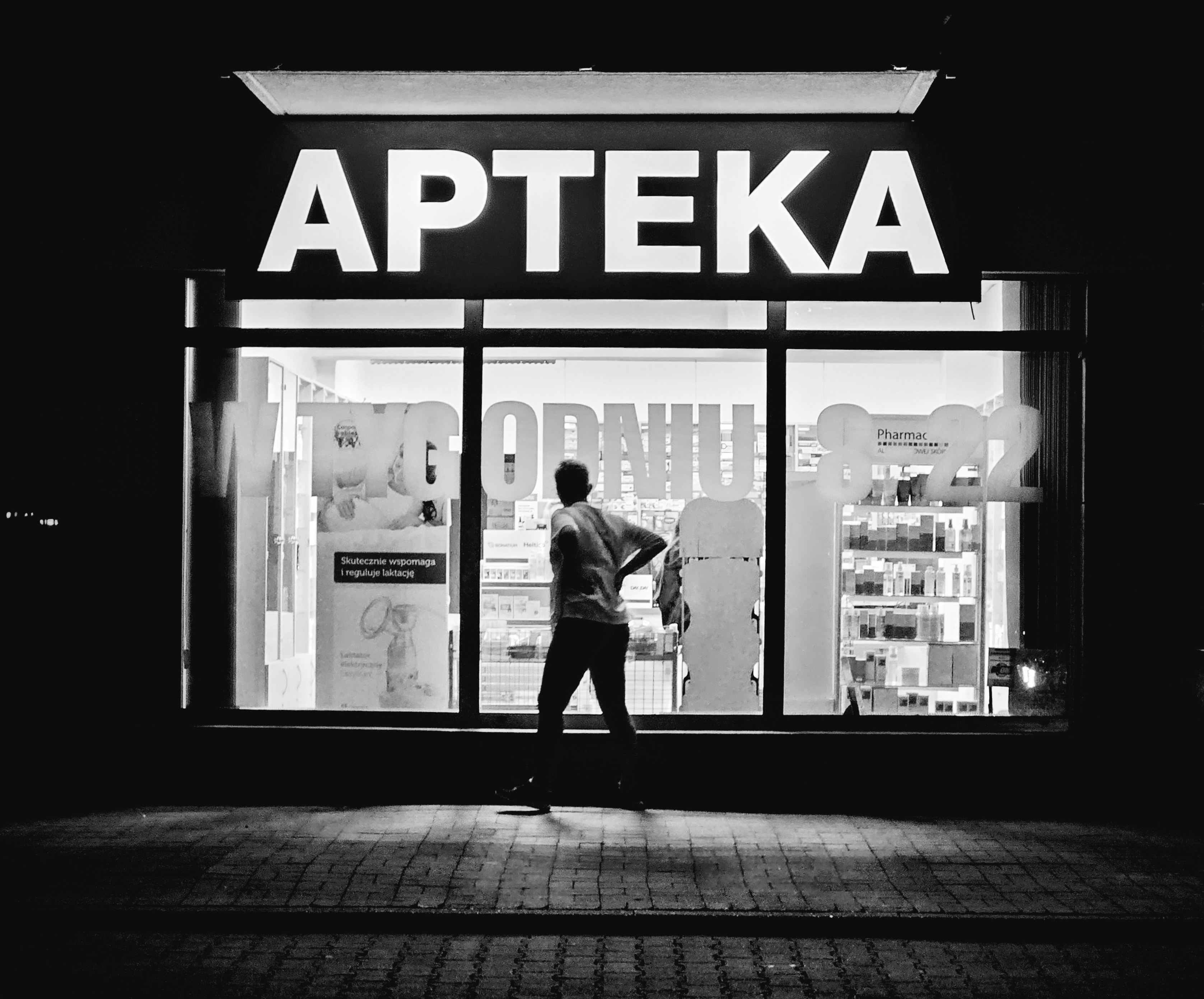 Un hombre parado frente a una tienda por la noche