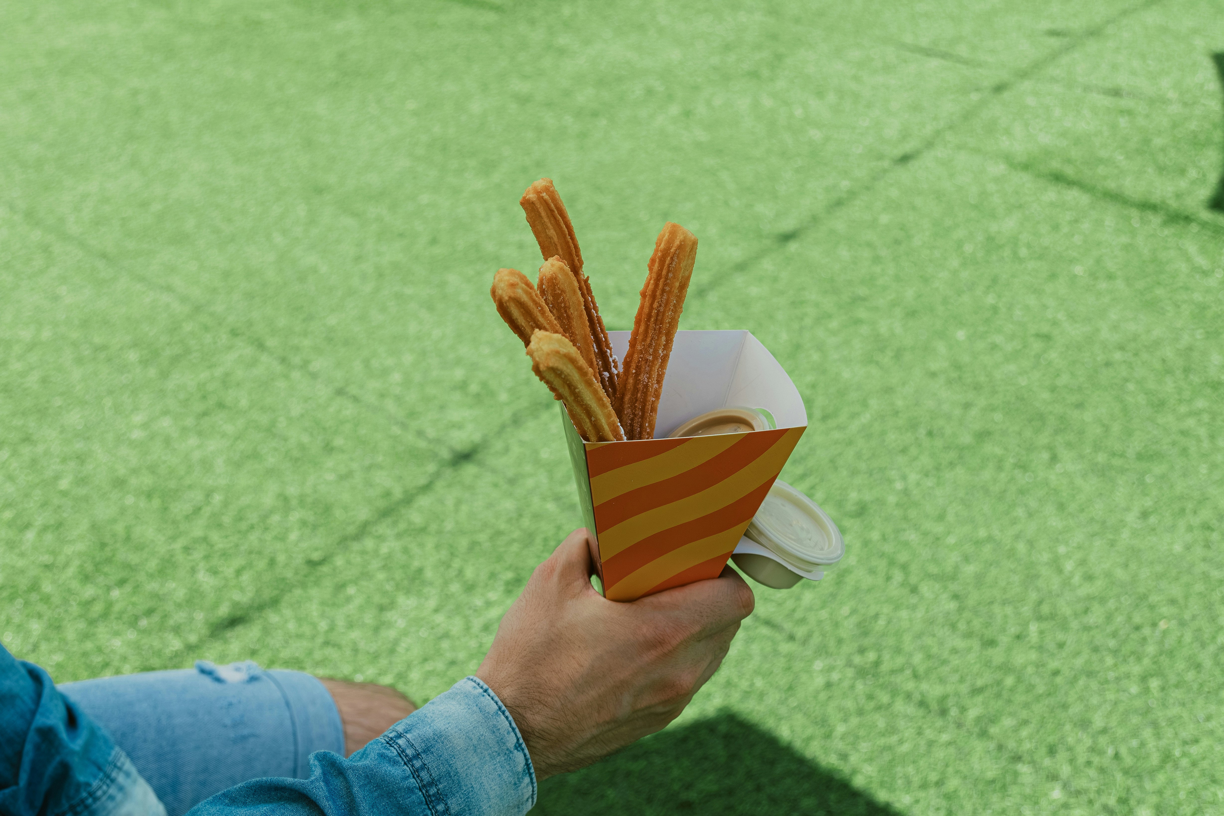 A person holding a box of fries in their hand