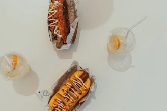 Two hotdogs and two drinks on a table