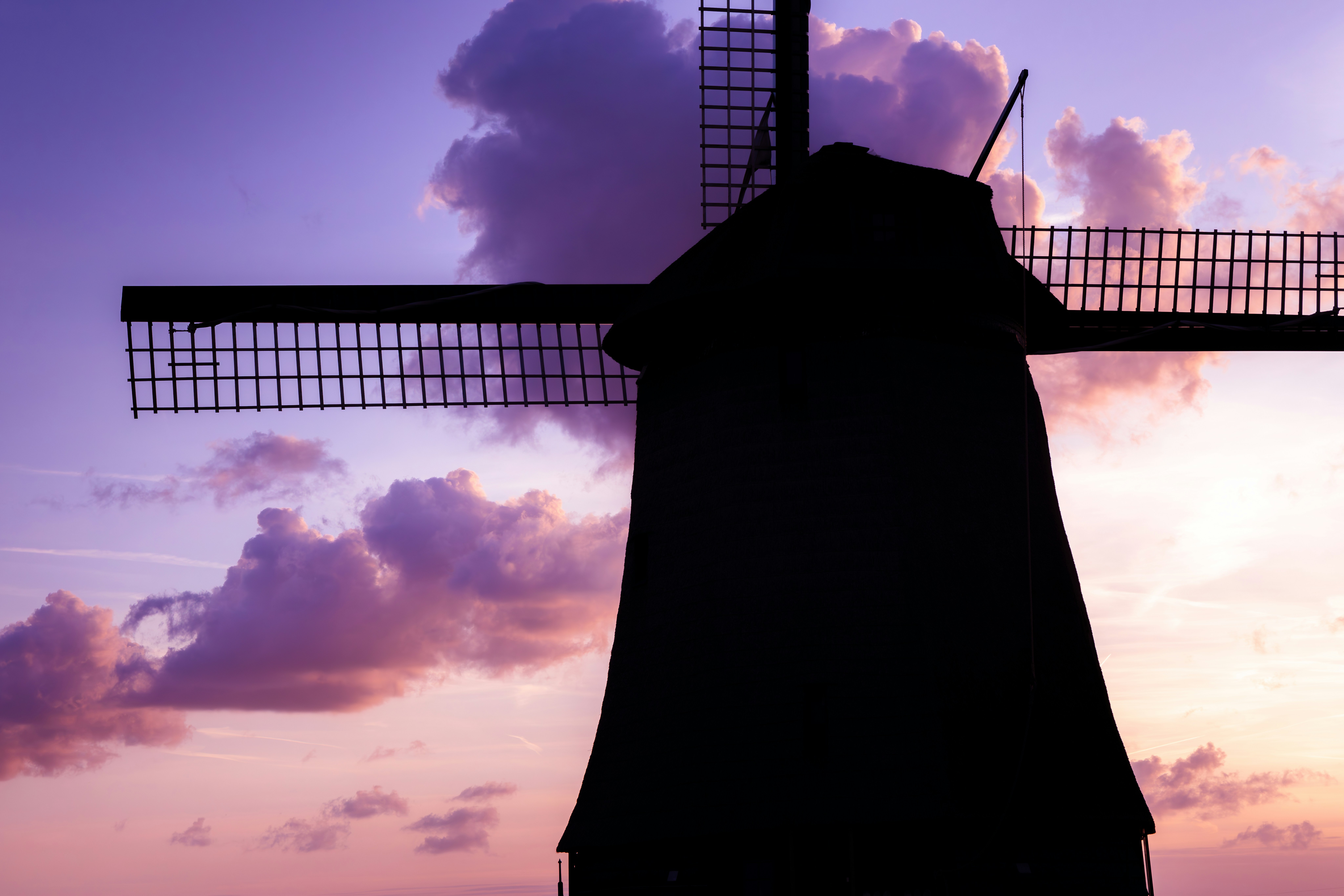 The silhouette of a windmill against a purple sky