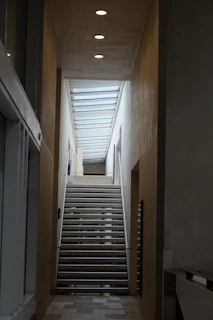 A long hallway with stairs leading up to a second floor
