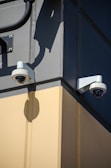 A couple of security cameras mounted to the side of a building