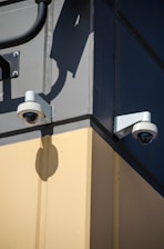 A couple of security cameras mounted to the side of a building