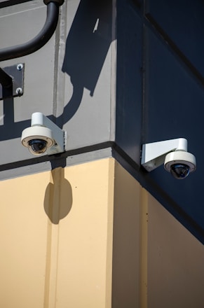 A couple of security cameras mounted to the side of a building