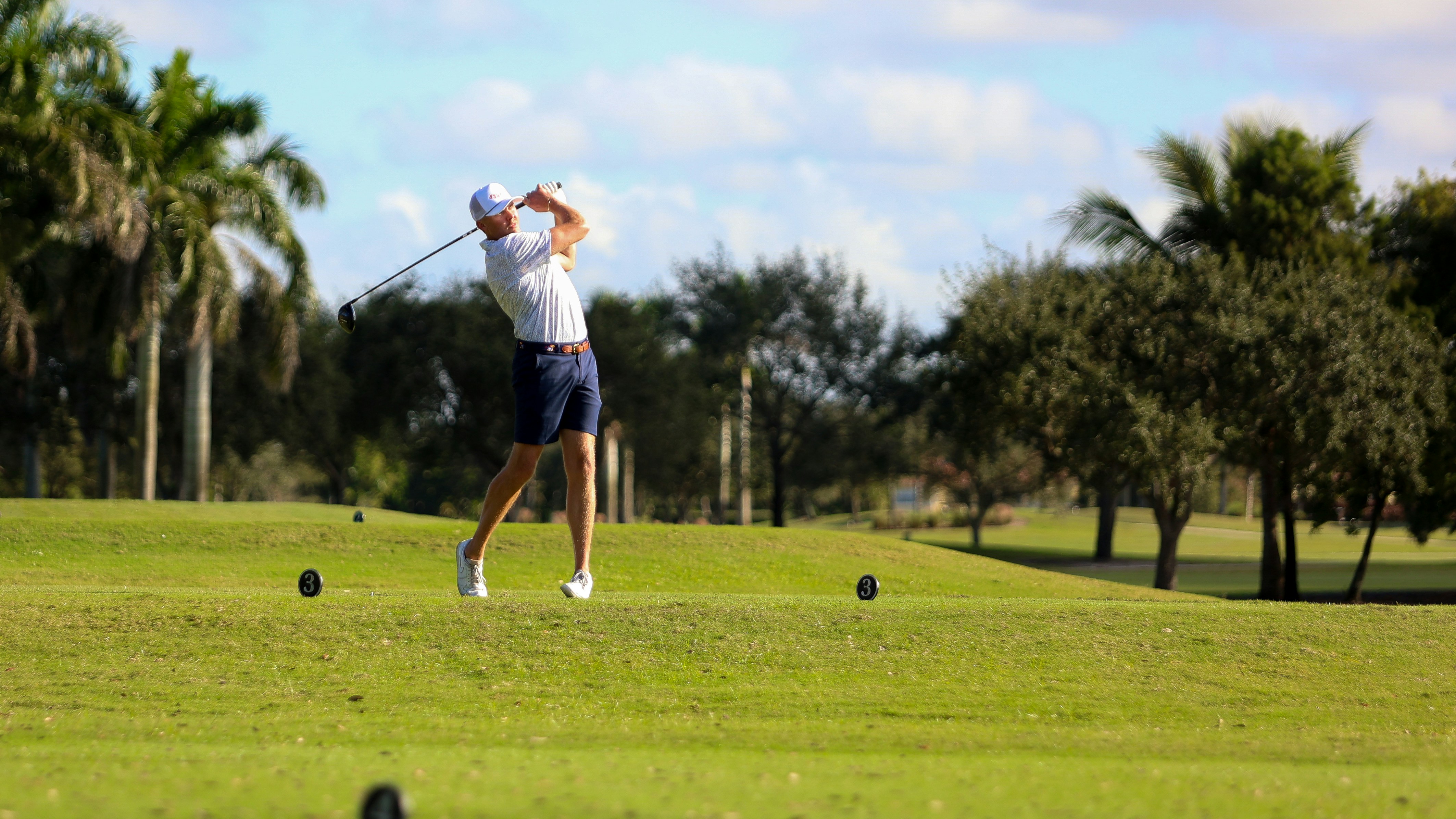 A man swinging a golf club on a golf course