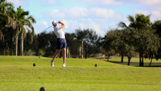 A man swinging a golf club on a golf course