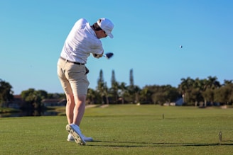 A man swinging a golf club on a golf course