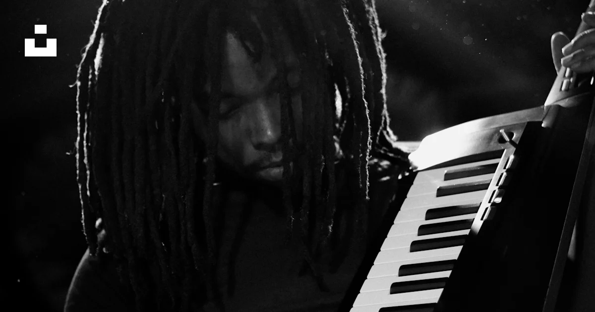 A man with dreadlocks playing an instrument photo – Free French quarter ...