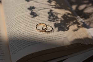 A couple of wedding rings sitting on top of an open book