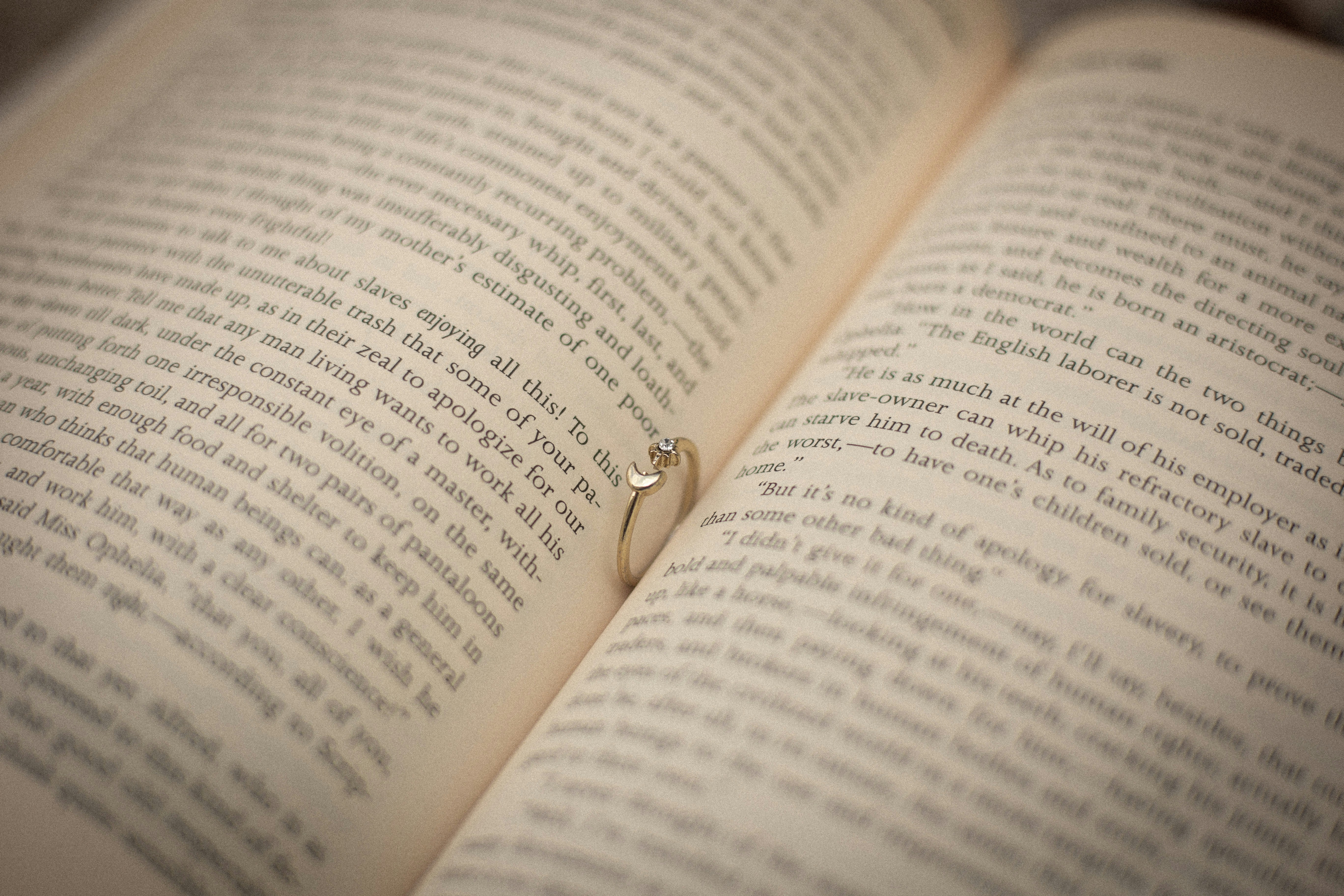 An open book with a ring on top of it