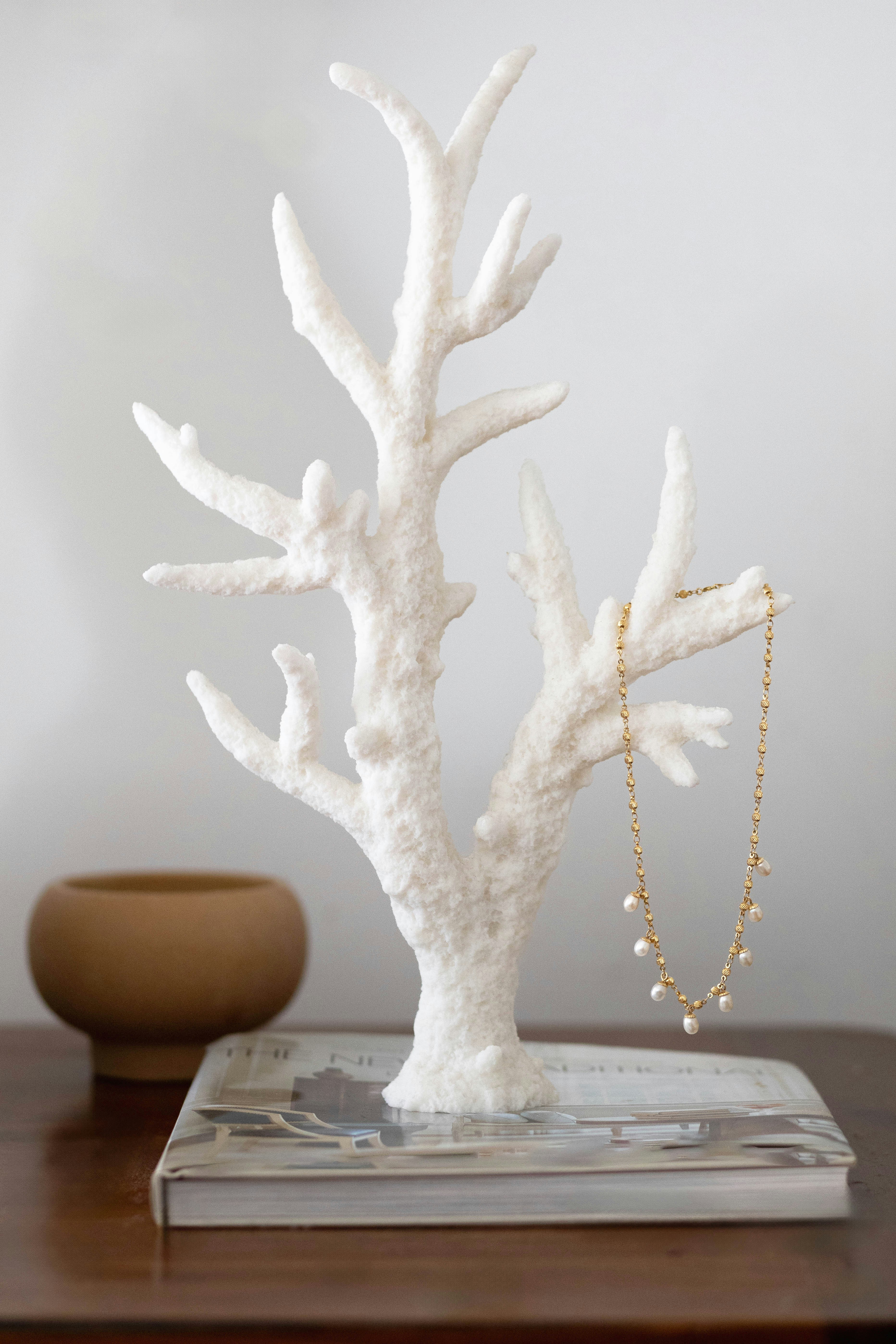 A white coral on a table next to a bowl