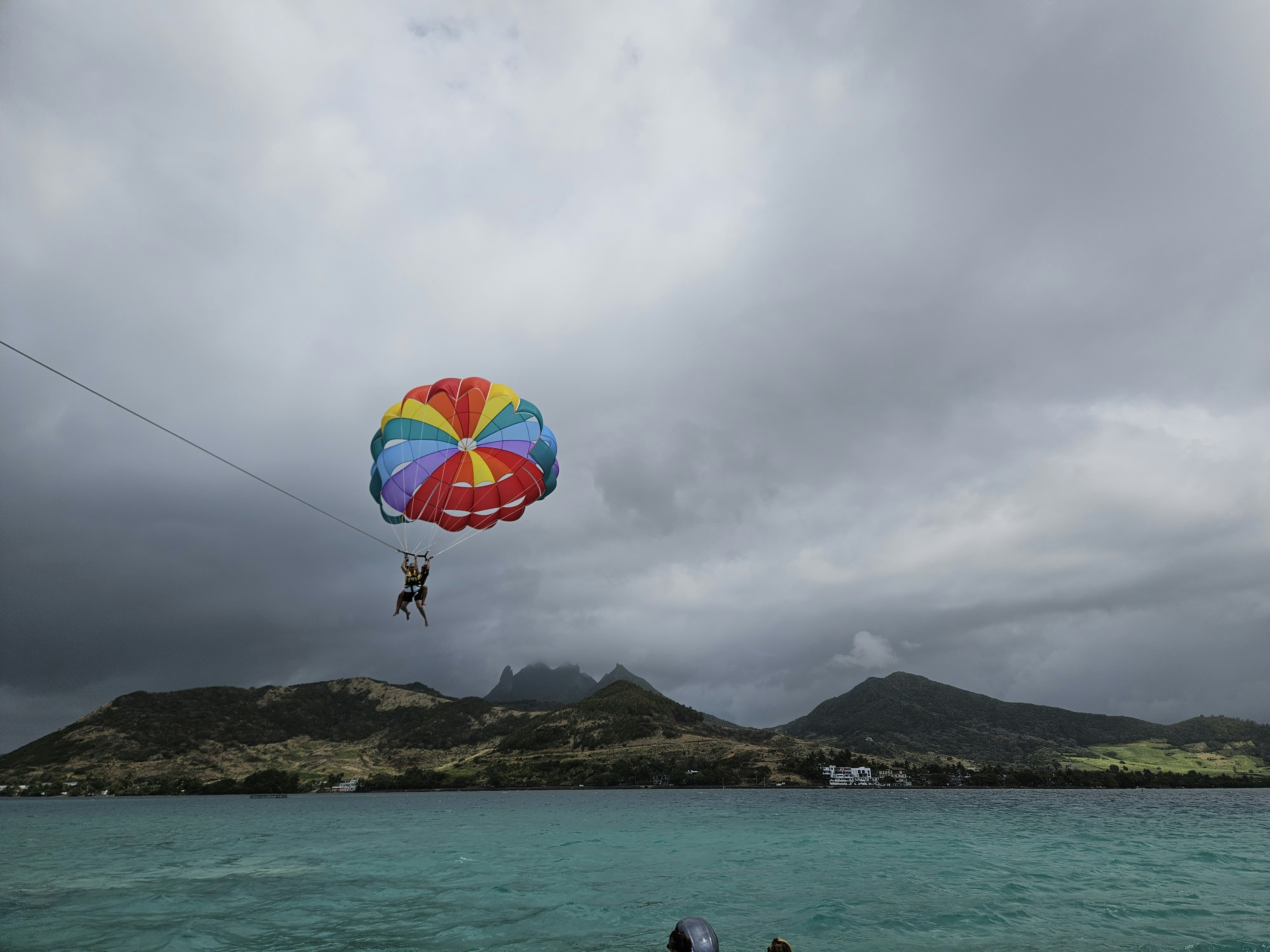 Person parasailing high above the Arabian Sea with Alibaug coastline visible below