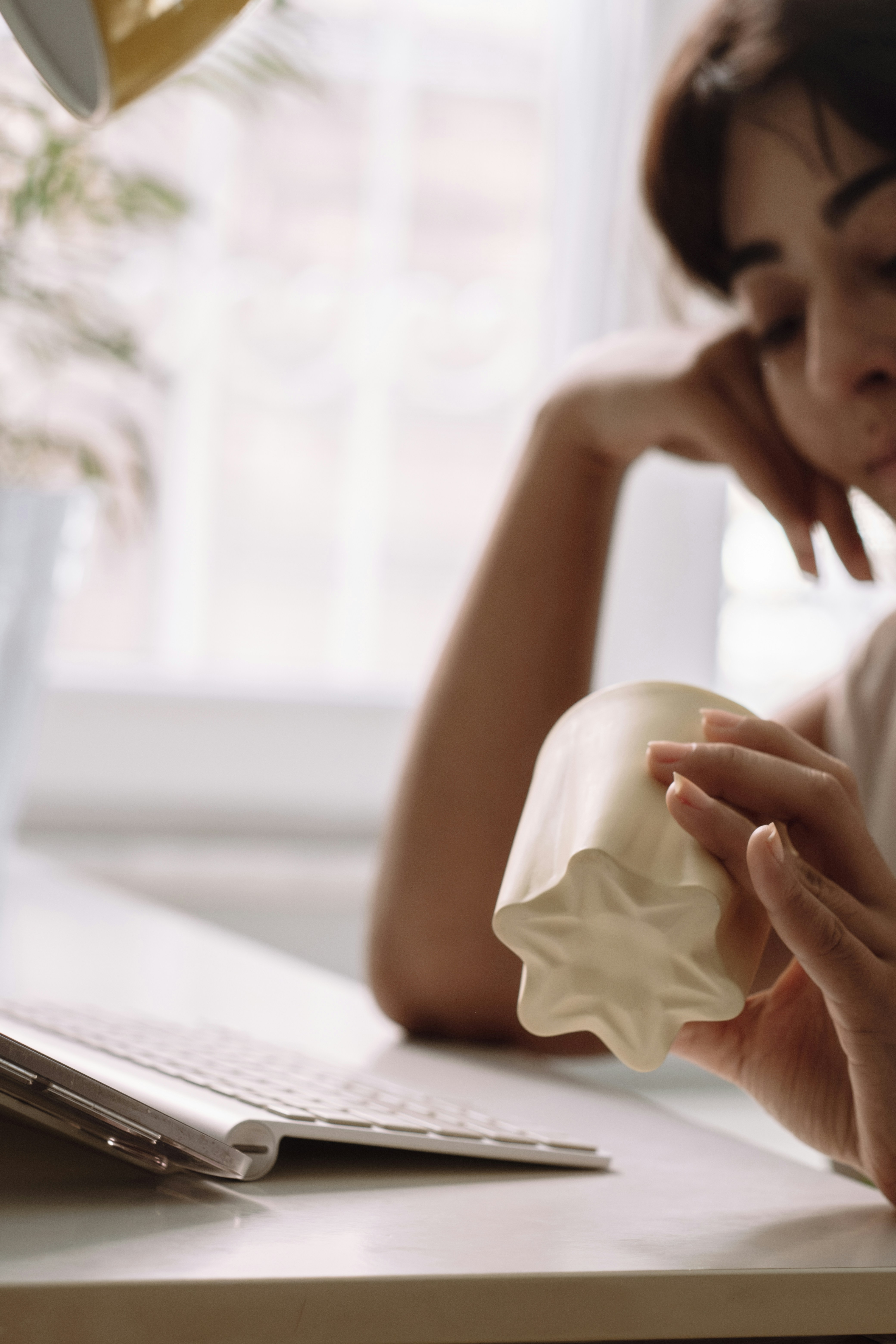 A woman sitting at a desk with a mug in front of her
