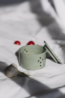 A tea cup and a spoon on a bed