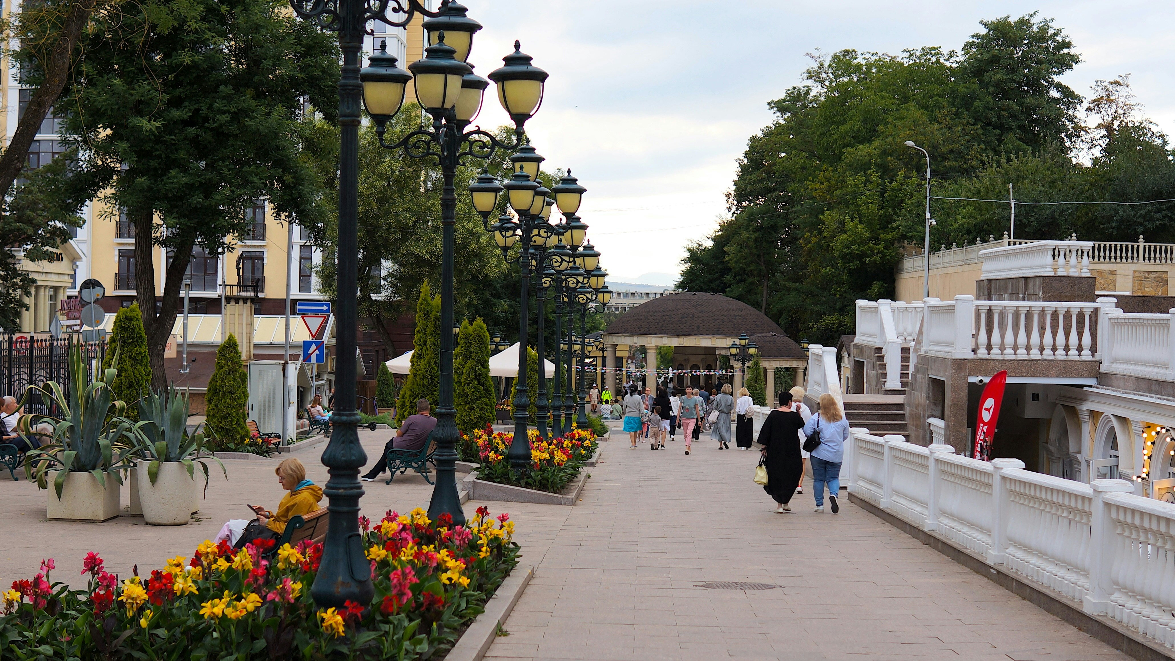 People walking down a walkway in a park