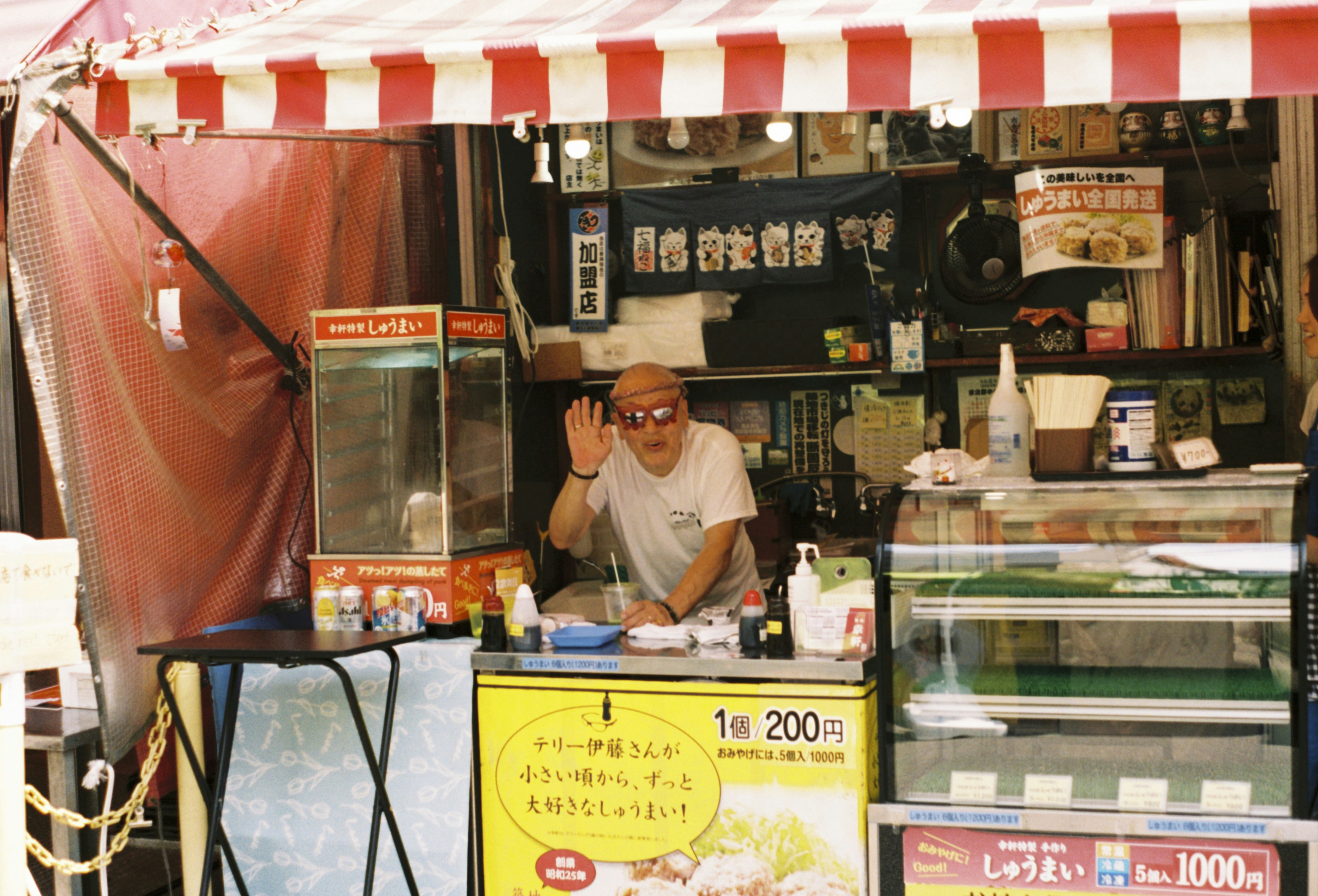 Un homme debout devant un stand de nourriture