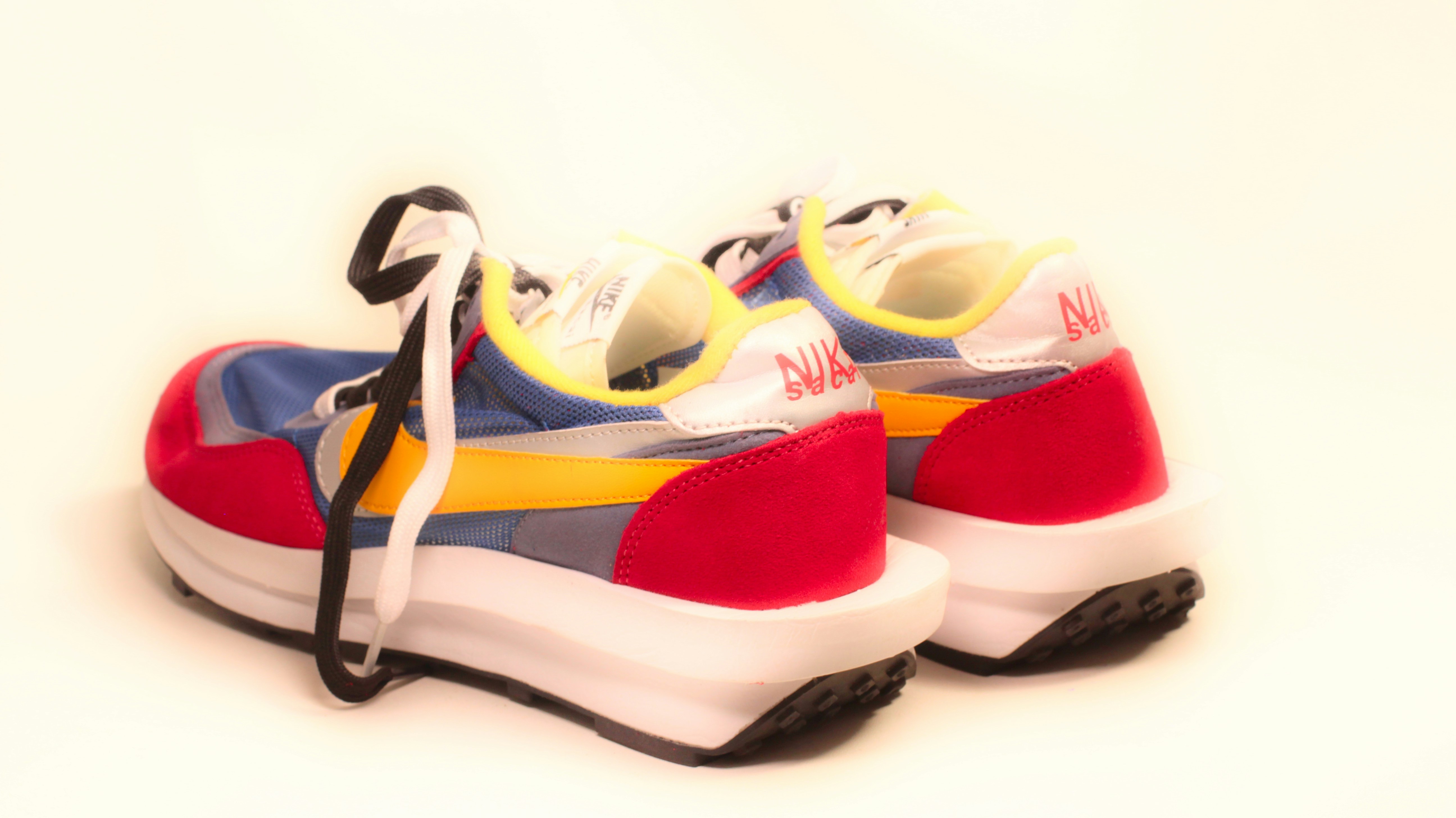 A pair of sneakers with colorful shoeslaces on them