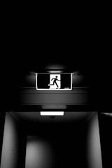 A man is walking down a dark hallway