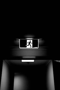 A man is walking down a dark hallway