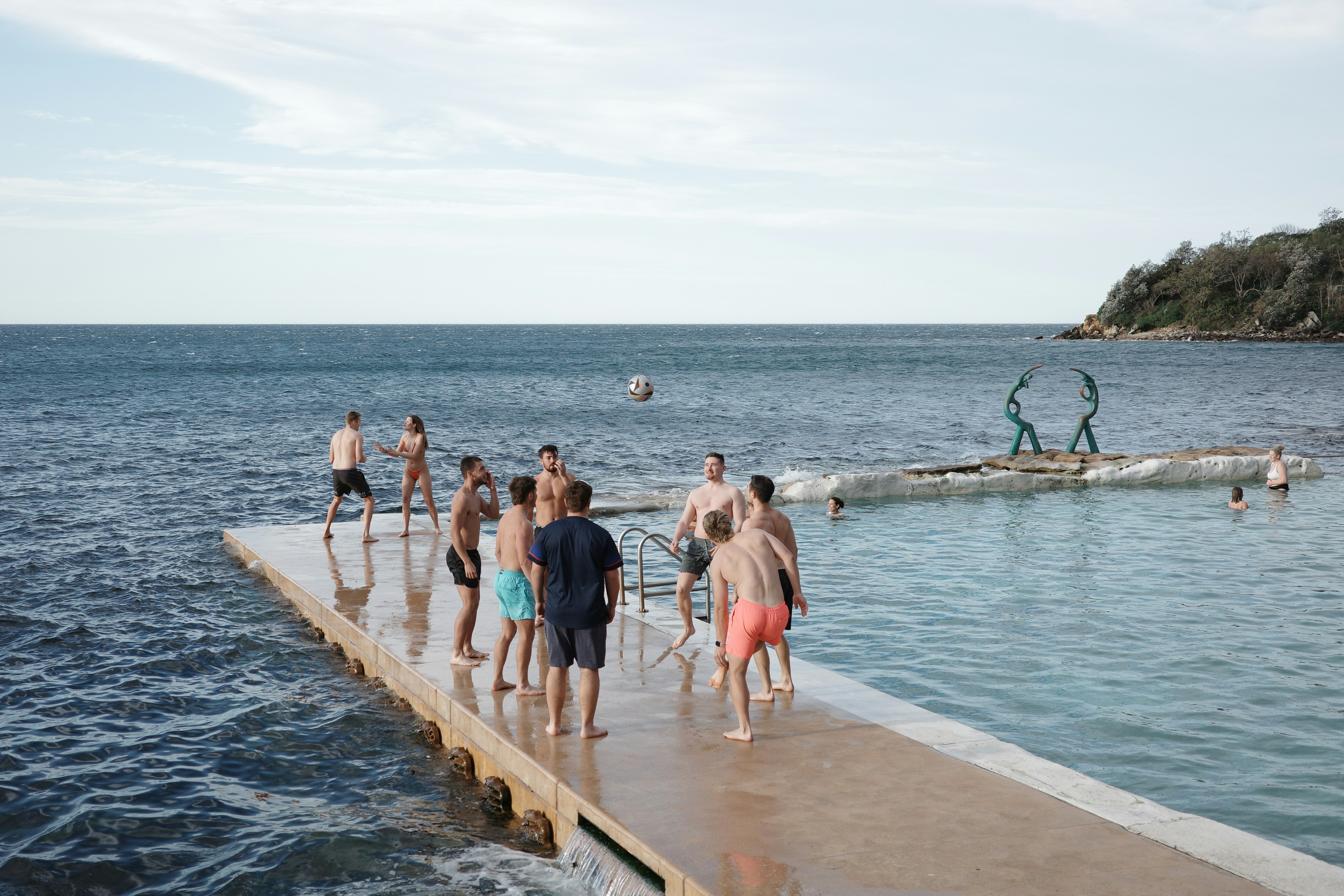 Un gruppo di persone in piedi su un molo vicino all'oceano