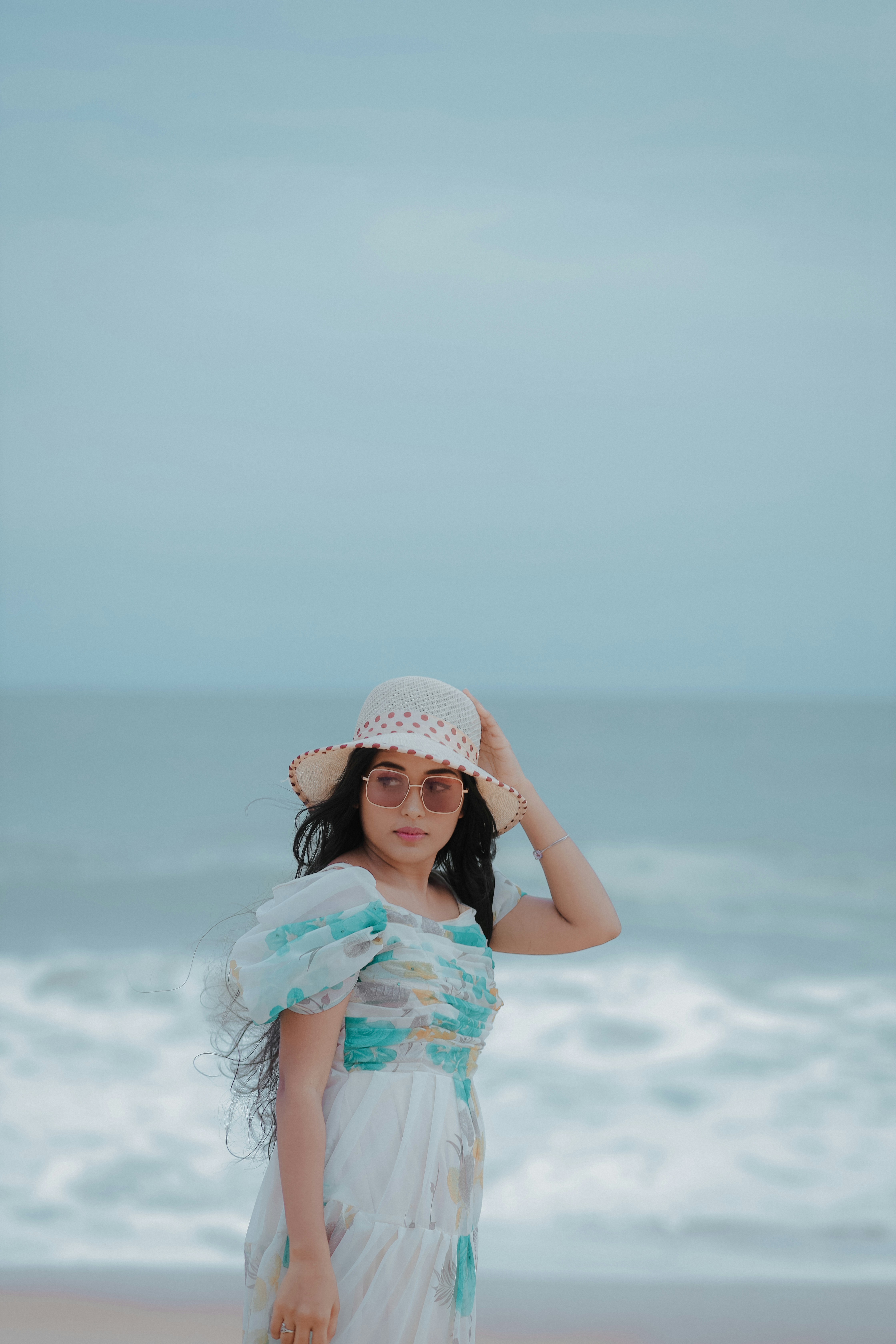 A woman in a white dress standing on a beach