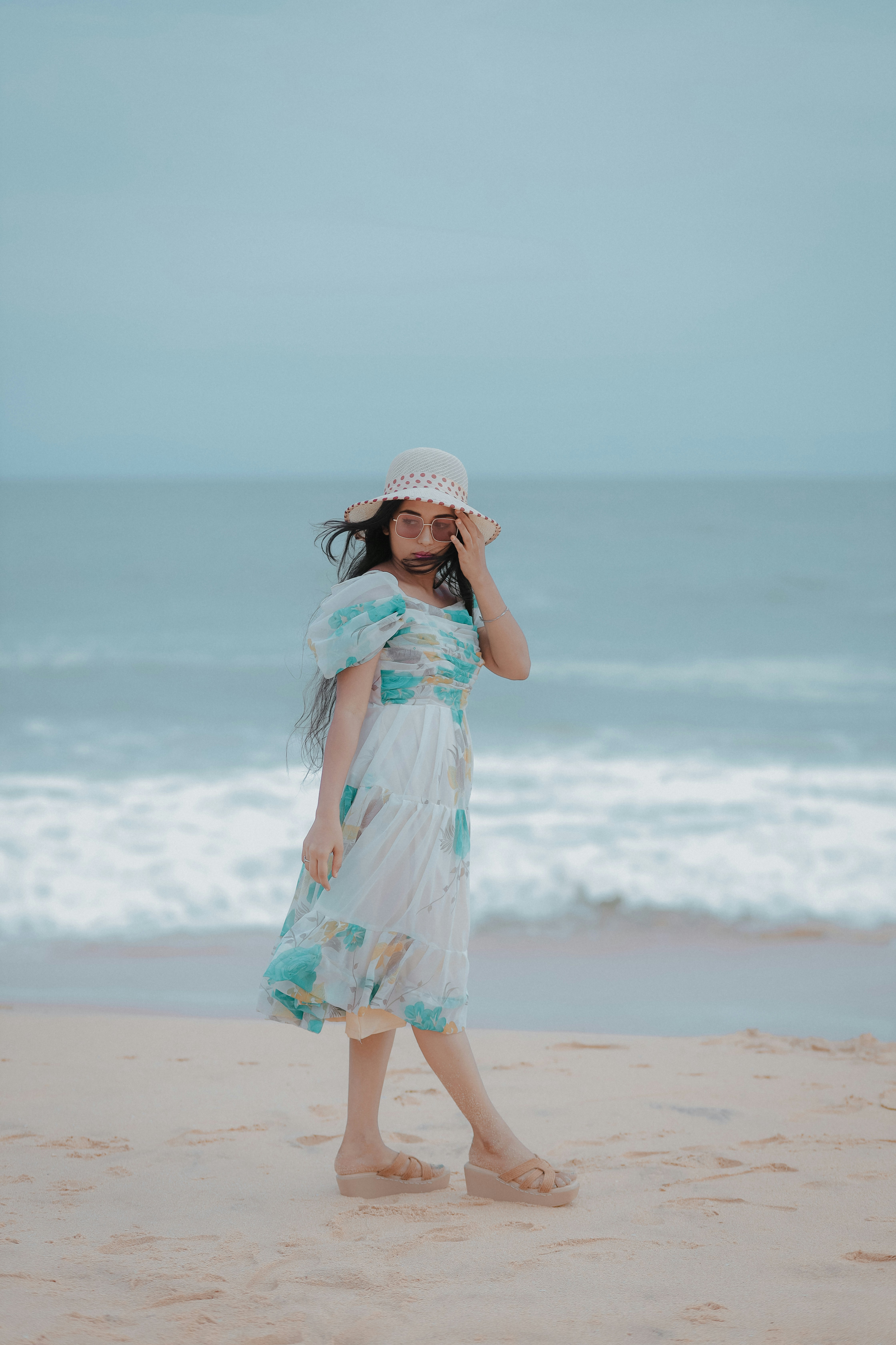 A woman walking on a beach next to the ocean