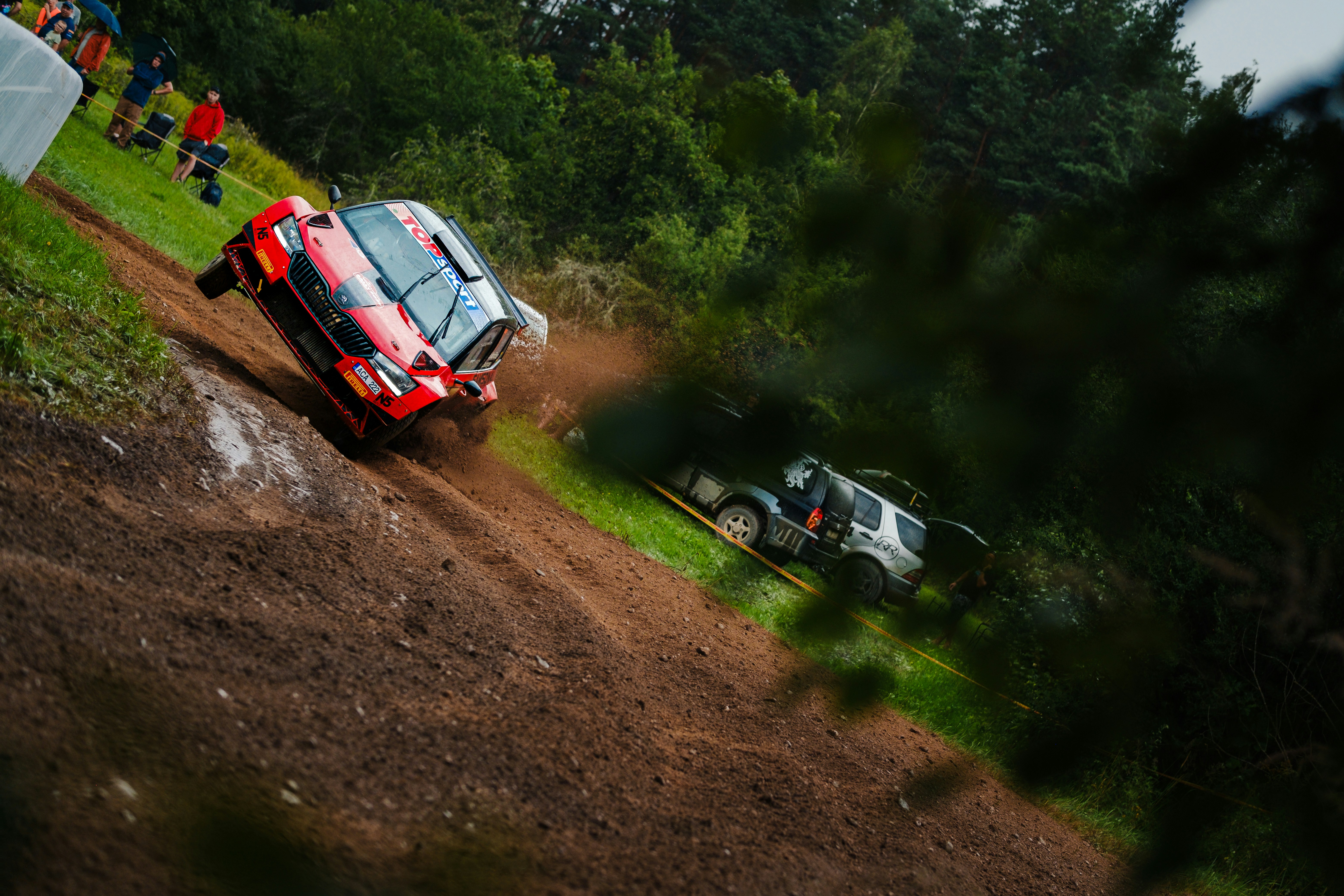 A couple of cars driving down a dirt road