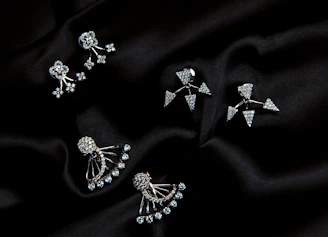 Three pairs of earrings on a black cloth