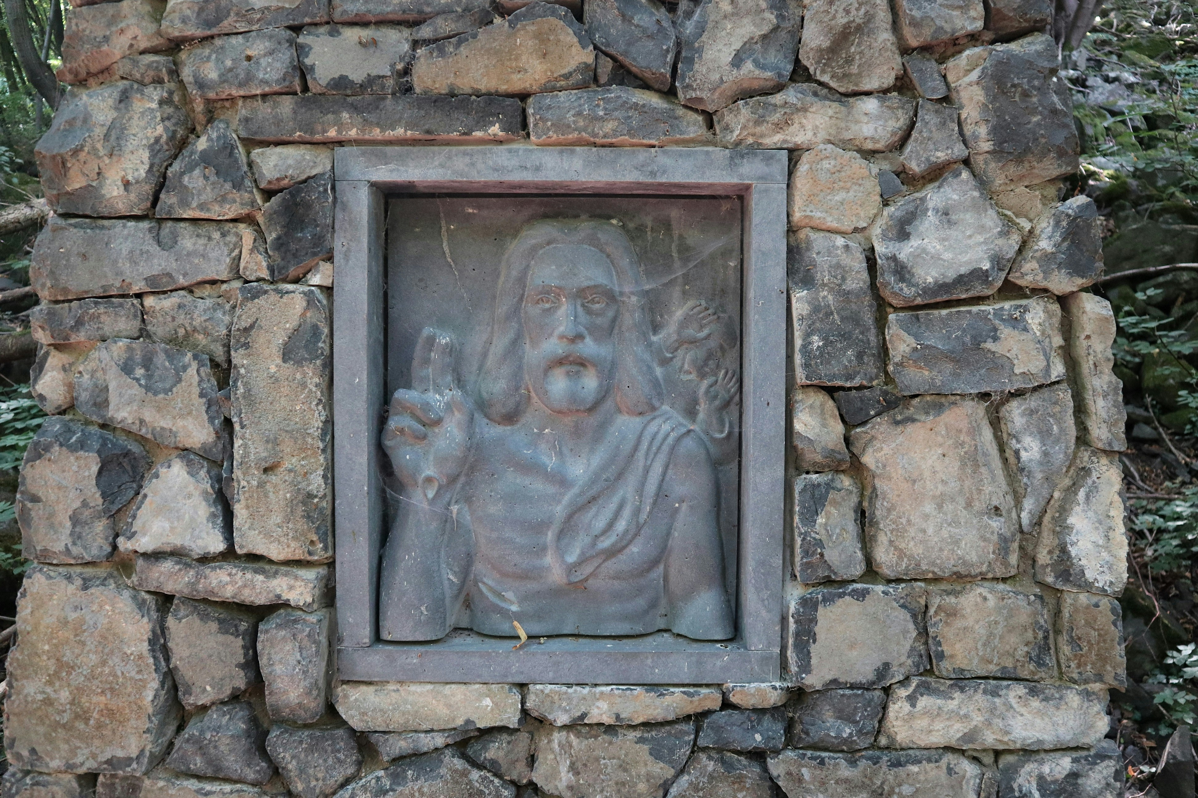 A statue of jesus on a stone wall