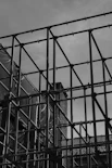 A black and white photo of a building behind a fence