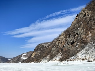 A person on skis in the snow near a mountain