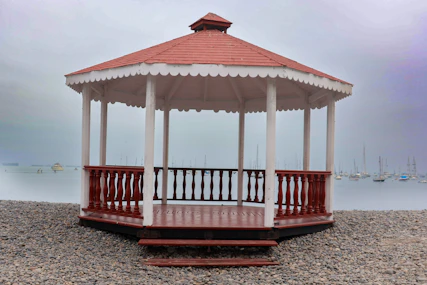 A red and white gazebo sitting on top of a sandy beach