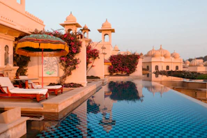 A large swimming pool with a lounge chair next to it
