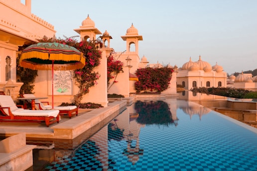 A large swimming pool with a lounge chair next to it