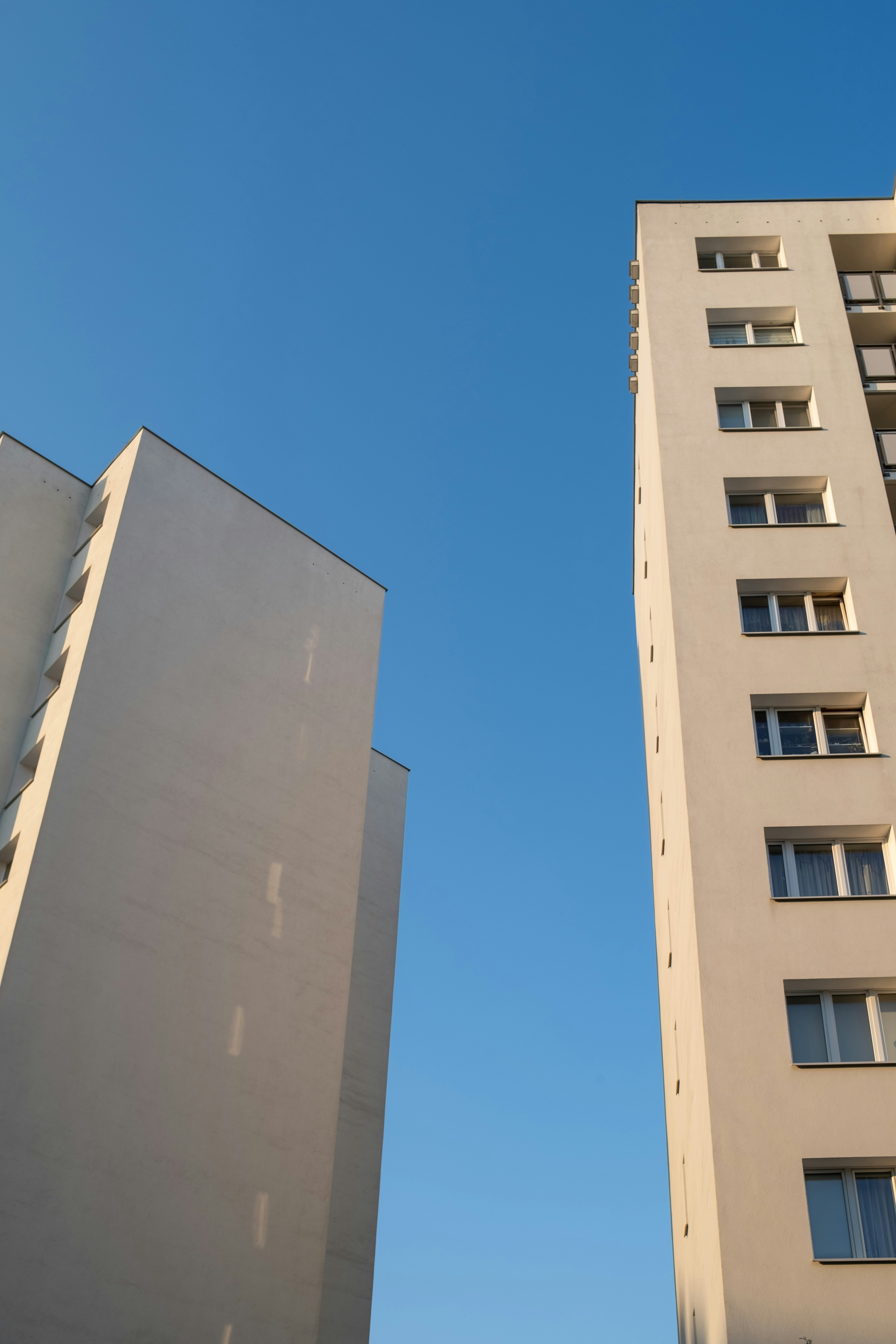 Two tall white buildings next to each other