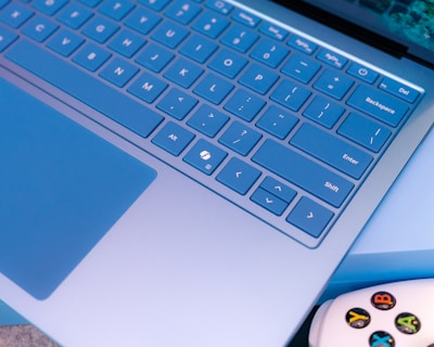 A close up of a laptop with a controller