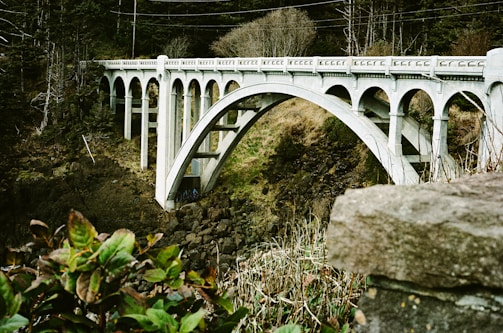 A white bridge over a river with power lines above it
