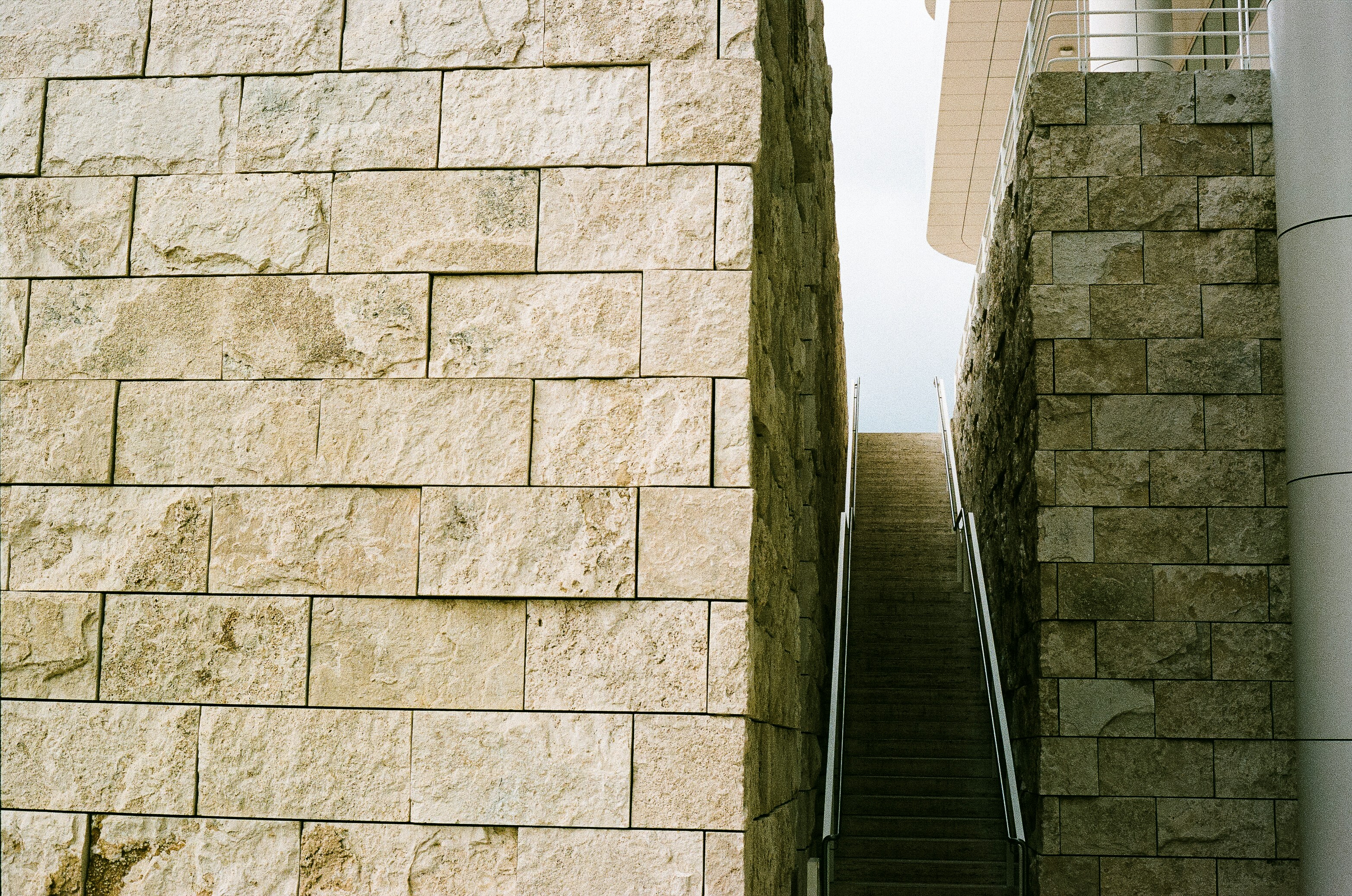 A stairway going up a stone wall next to a building