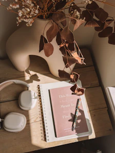 A book, headphones, and a plant on a table