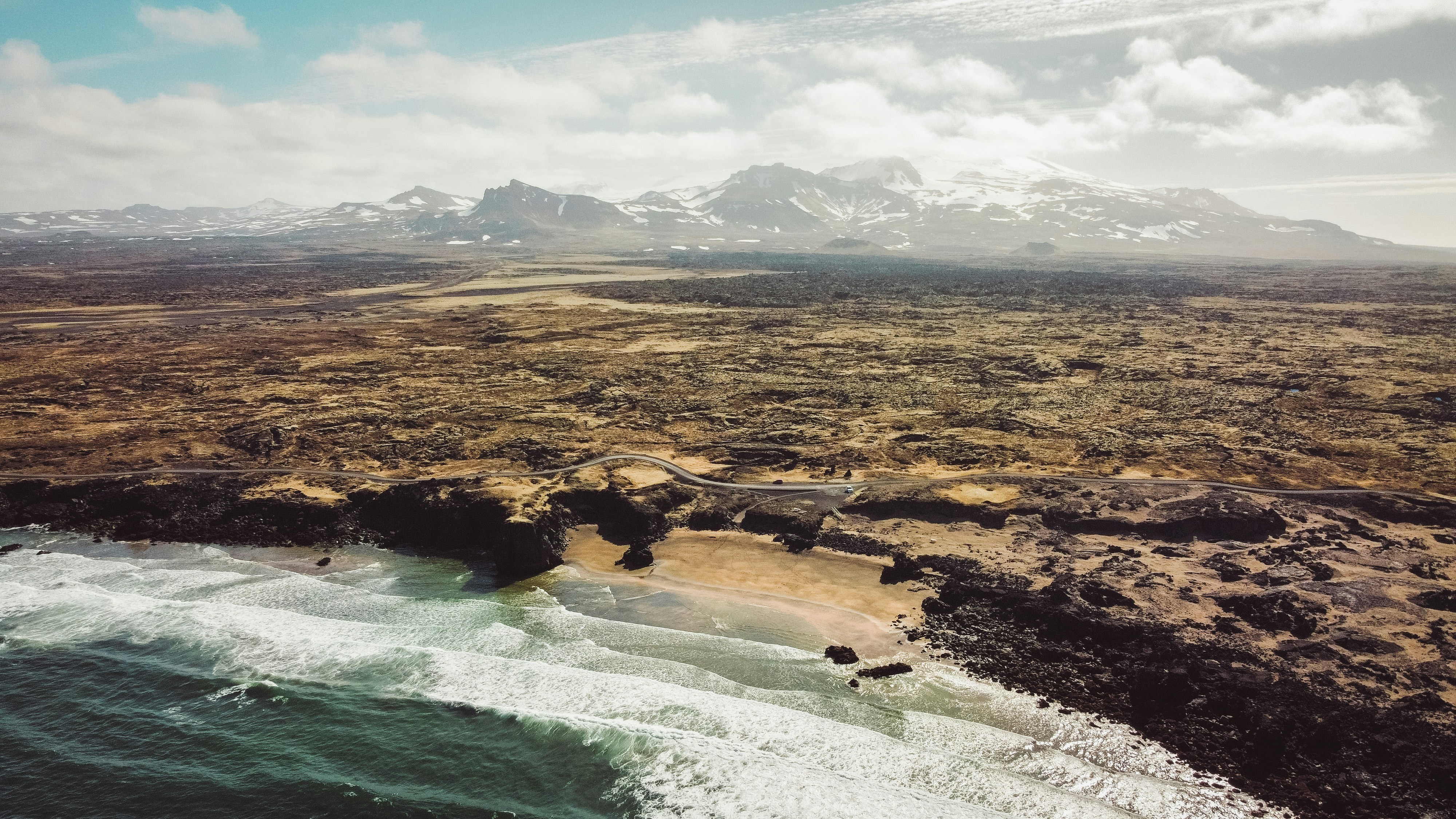 An aerial view of a beach with a mountain in the background