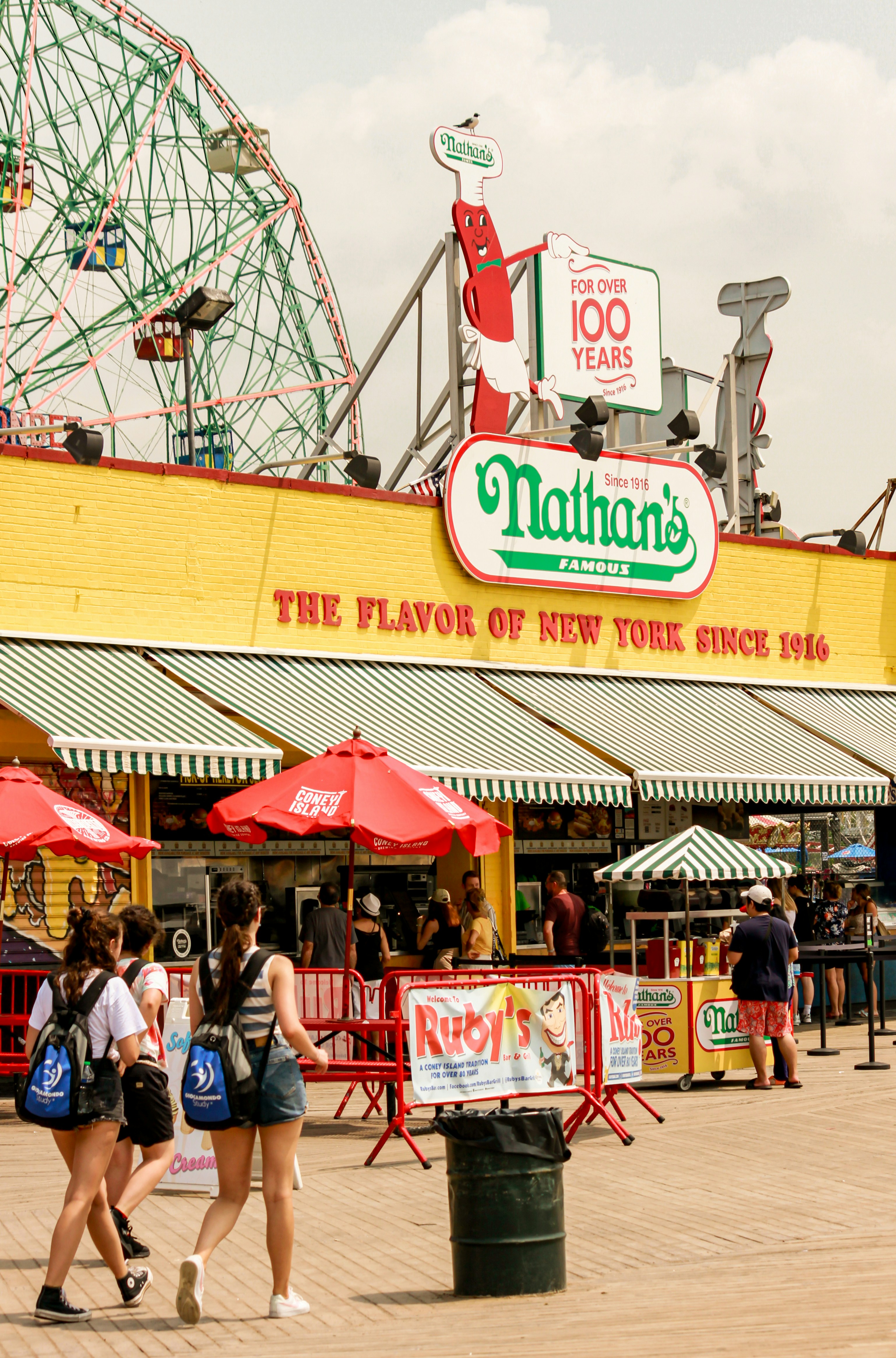 A group of people walking in front of a carnival