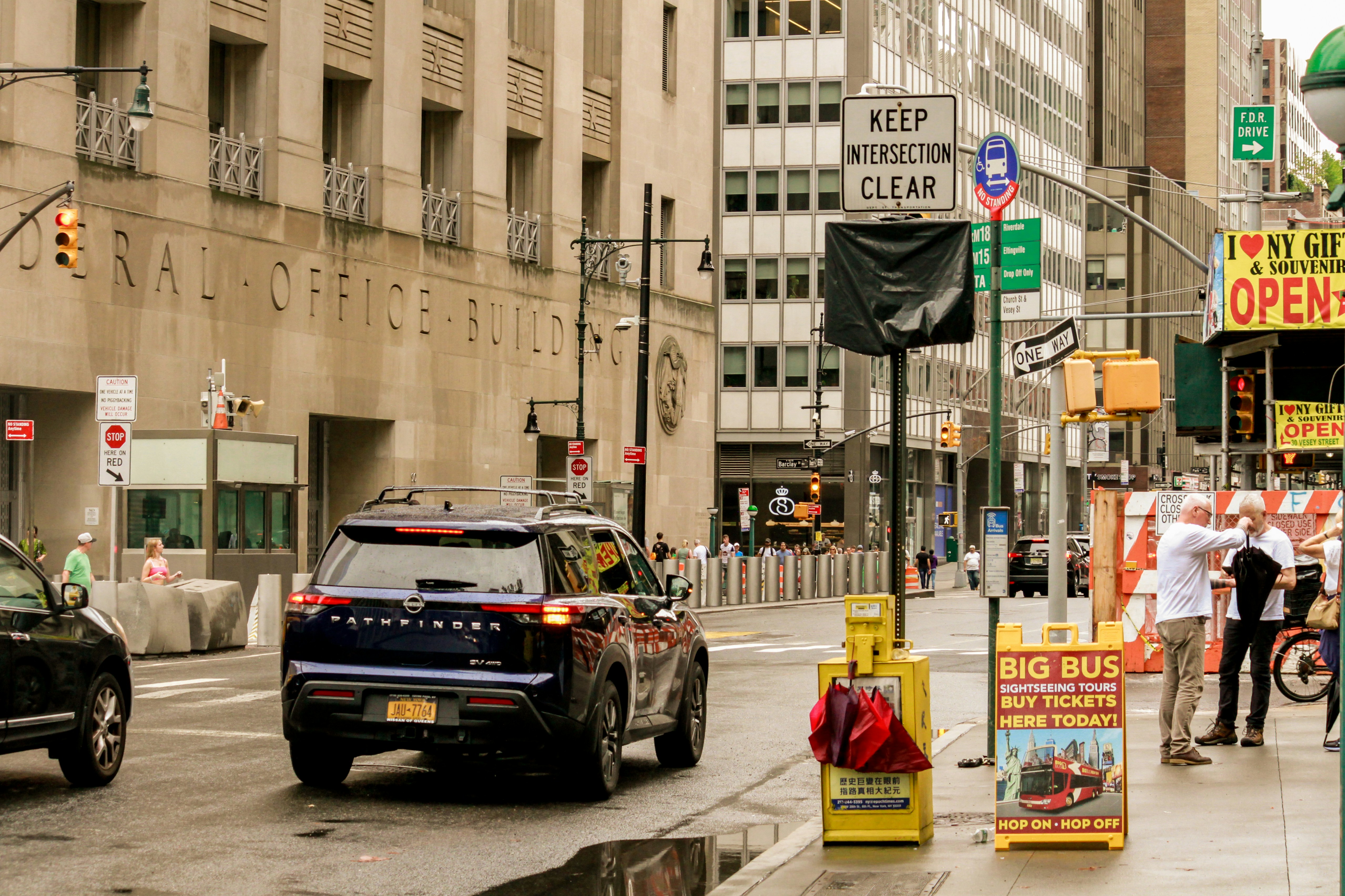A city street filled with lots of traffic next to tall buildings