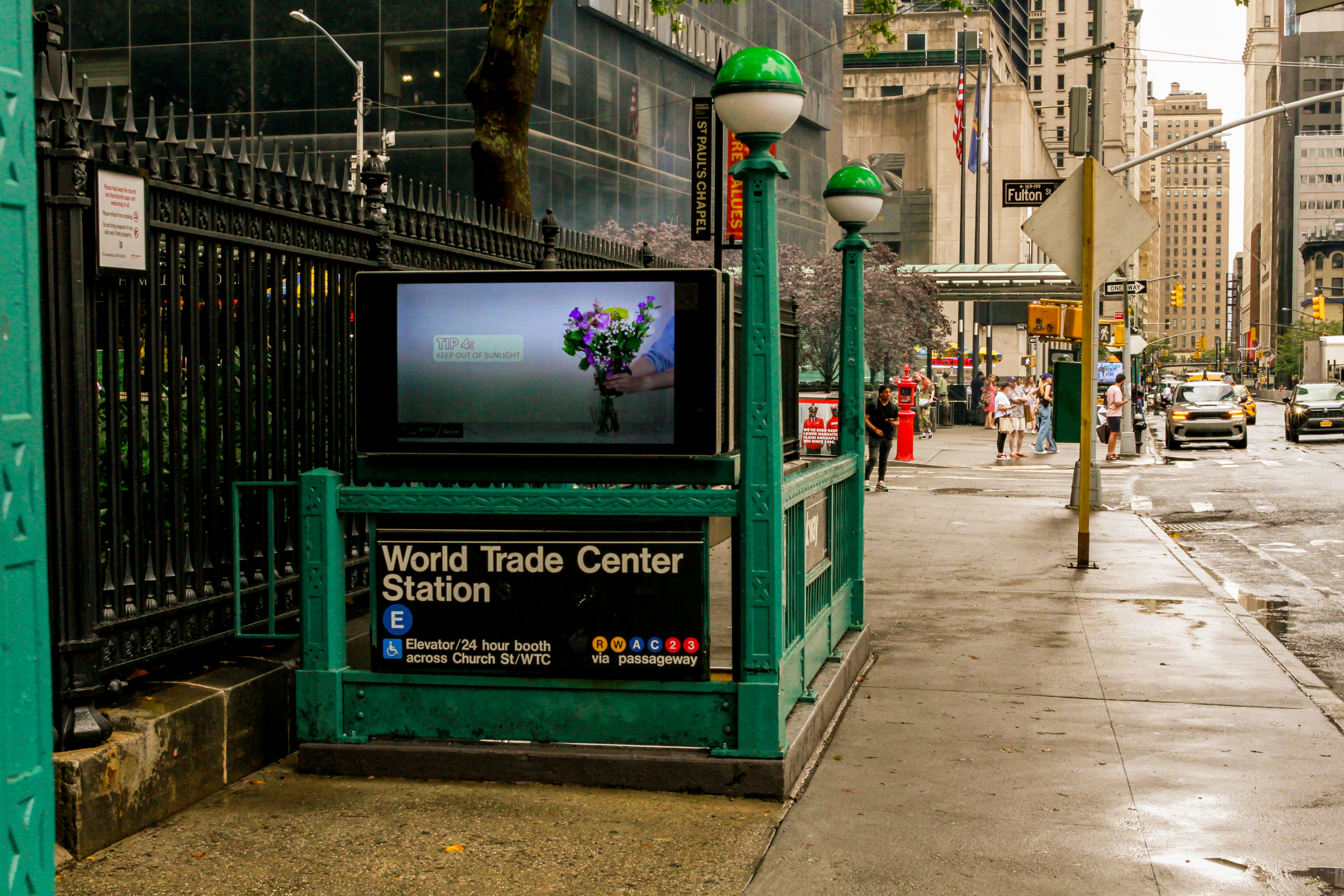 A city sidewalk with a TV on the corner