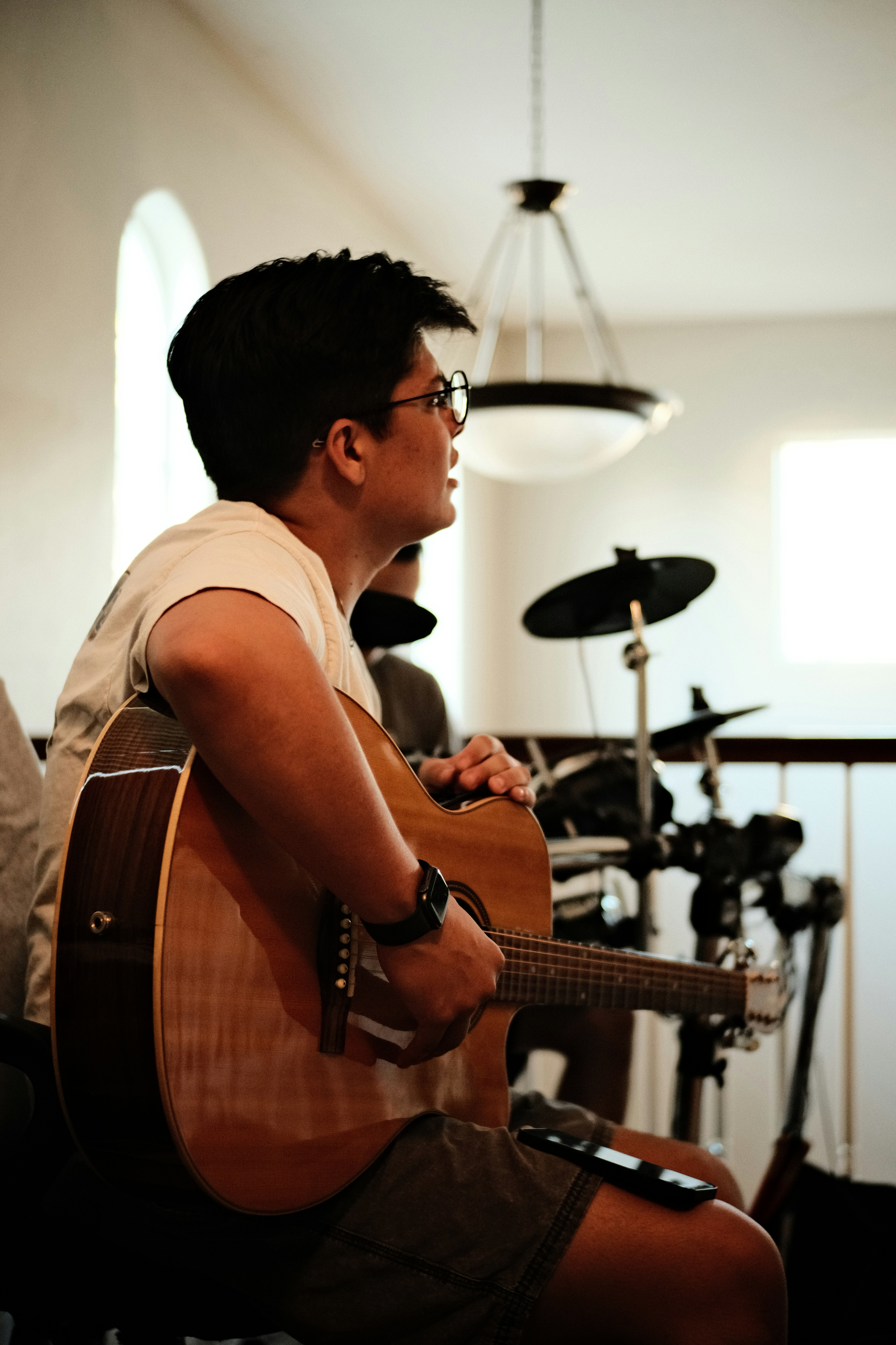 A man sitting in a chair playing a guitar photo – Free Electrical ...
