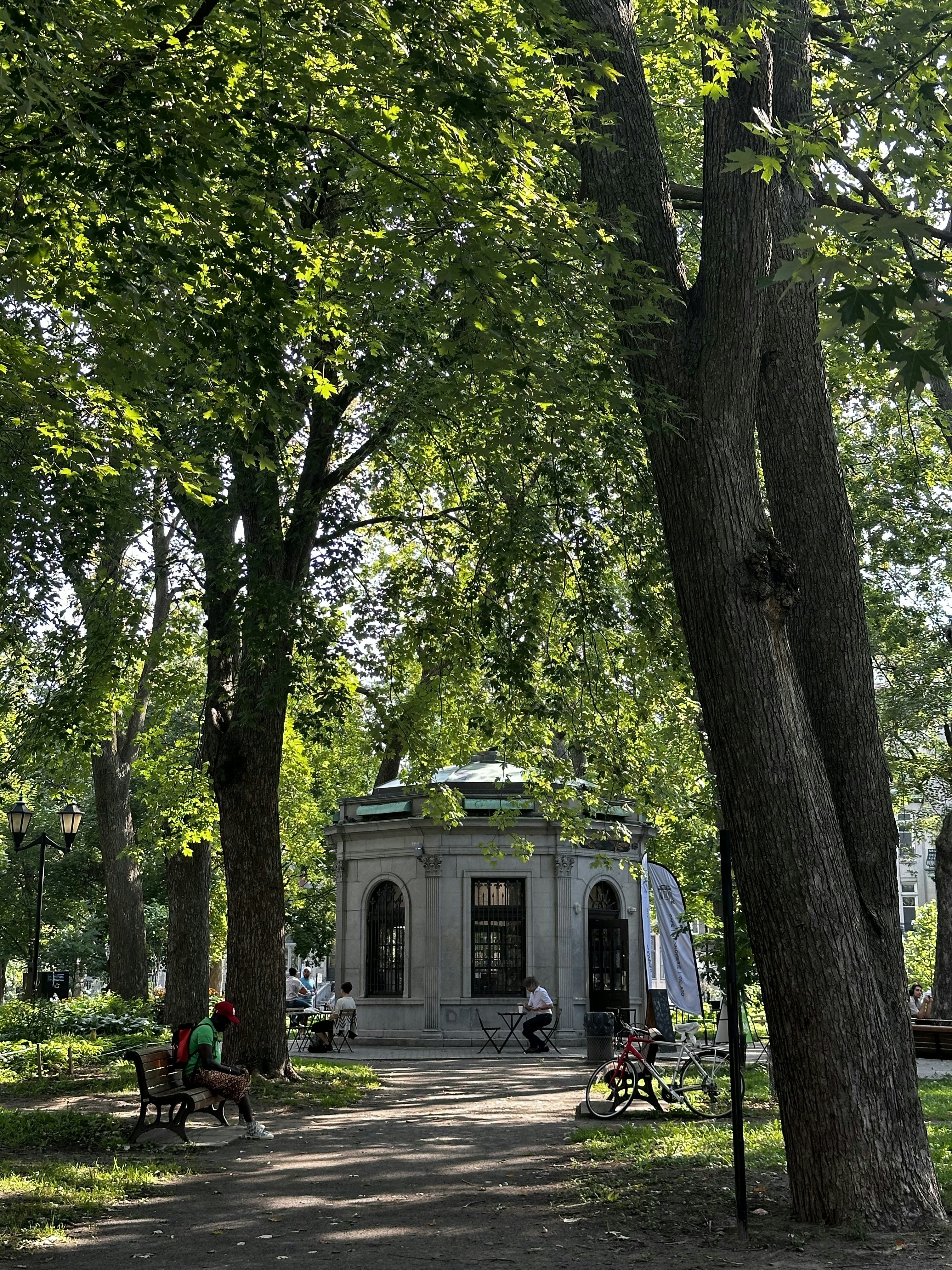 A park with benches, trees, and a monument