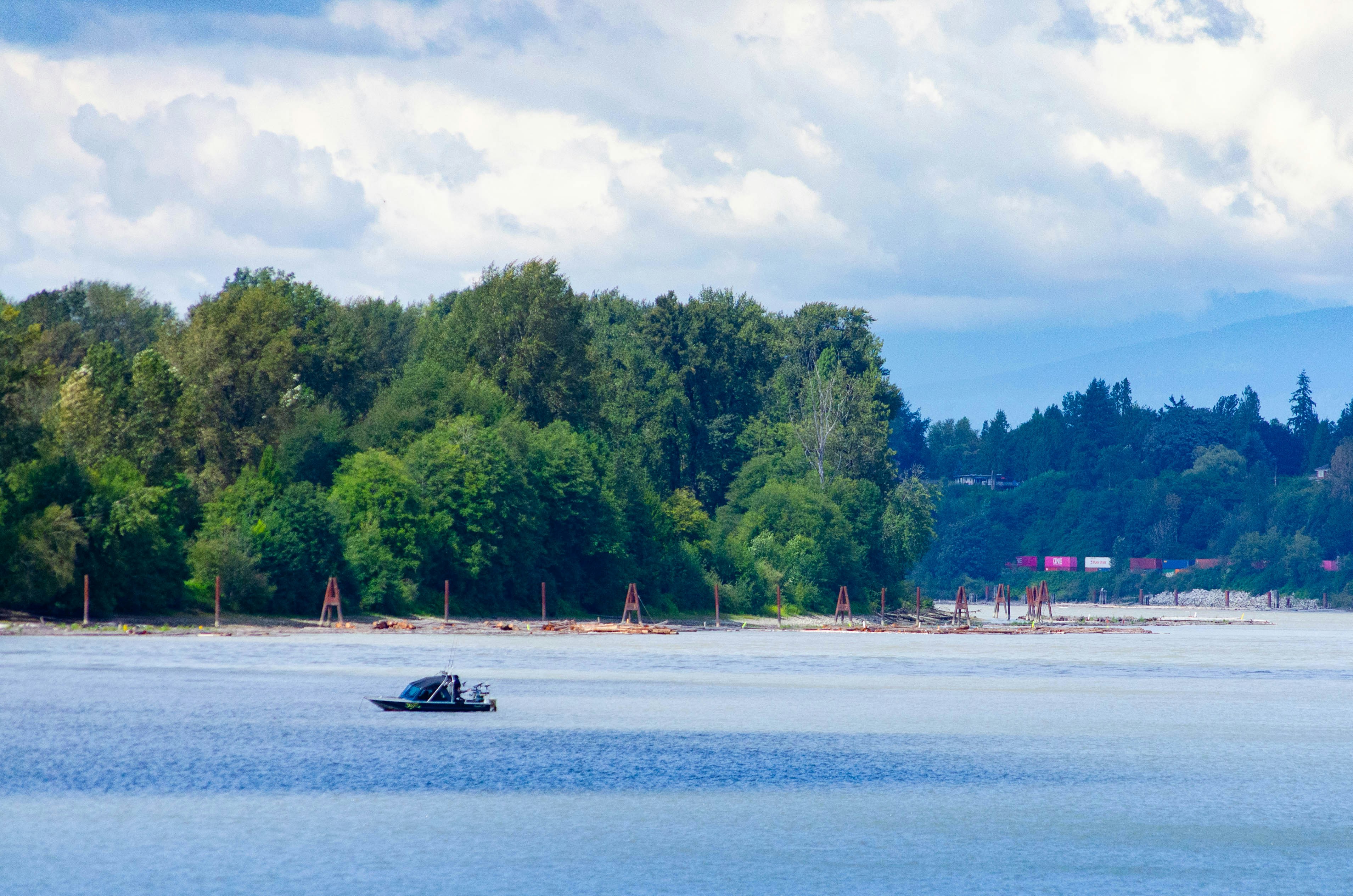 A boat floating on top of a lake surrounded by trees