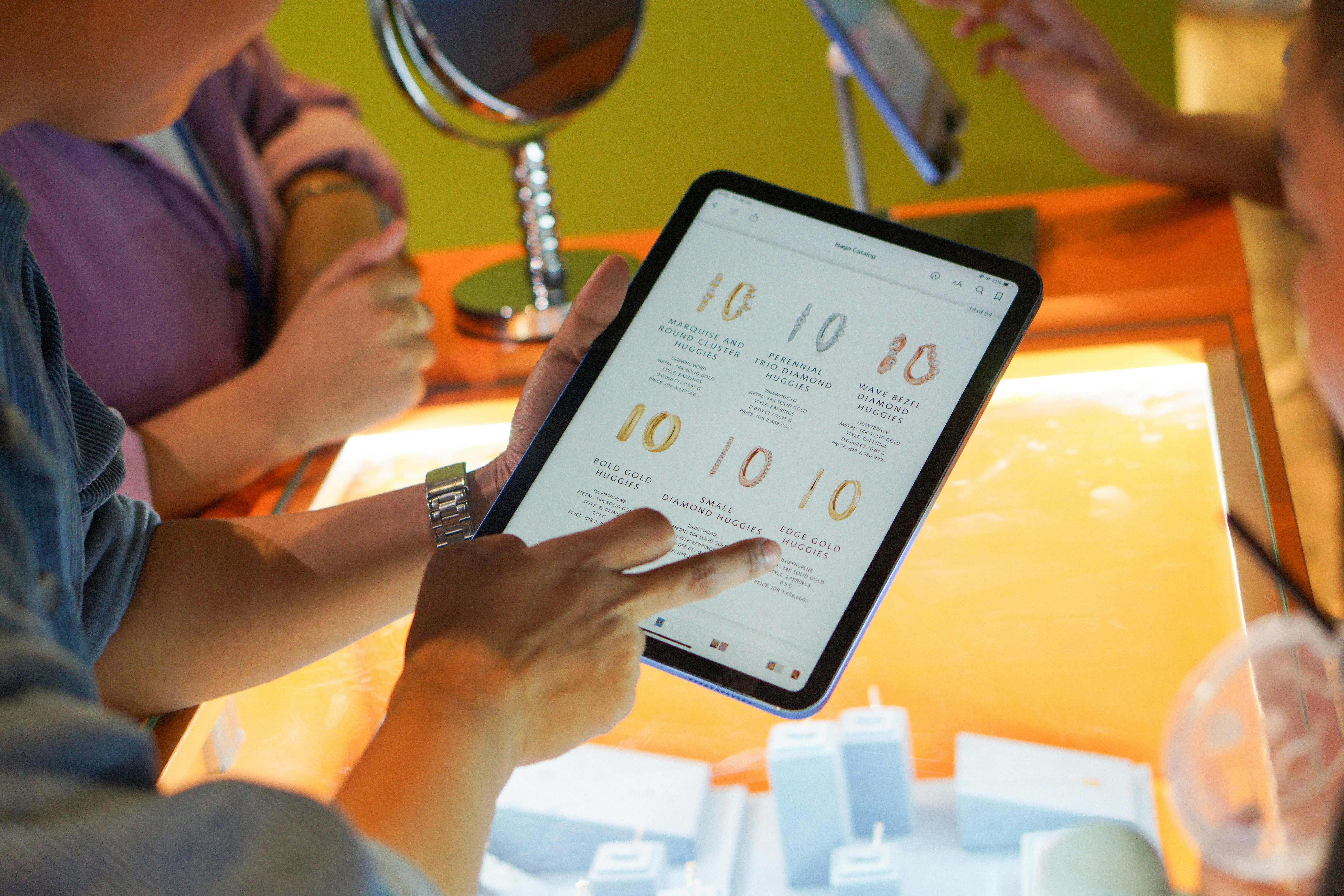 A group of people sitting around a table with a tablet