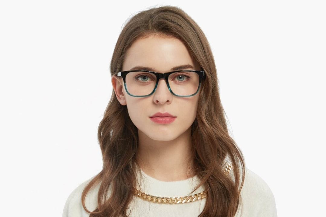 A woman wearing glasses and a sweater, The young woman
