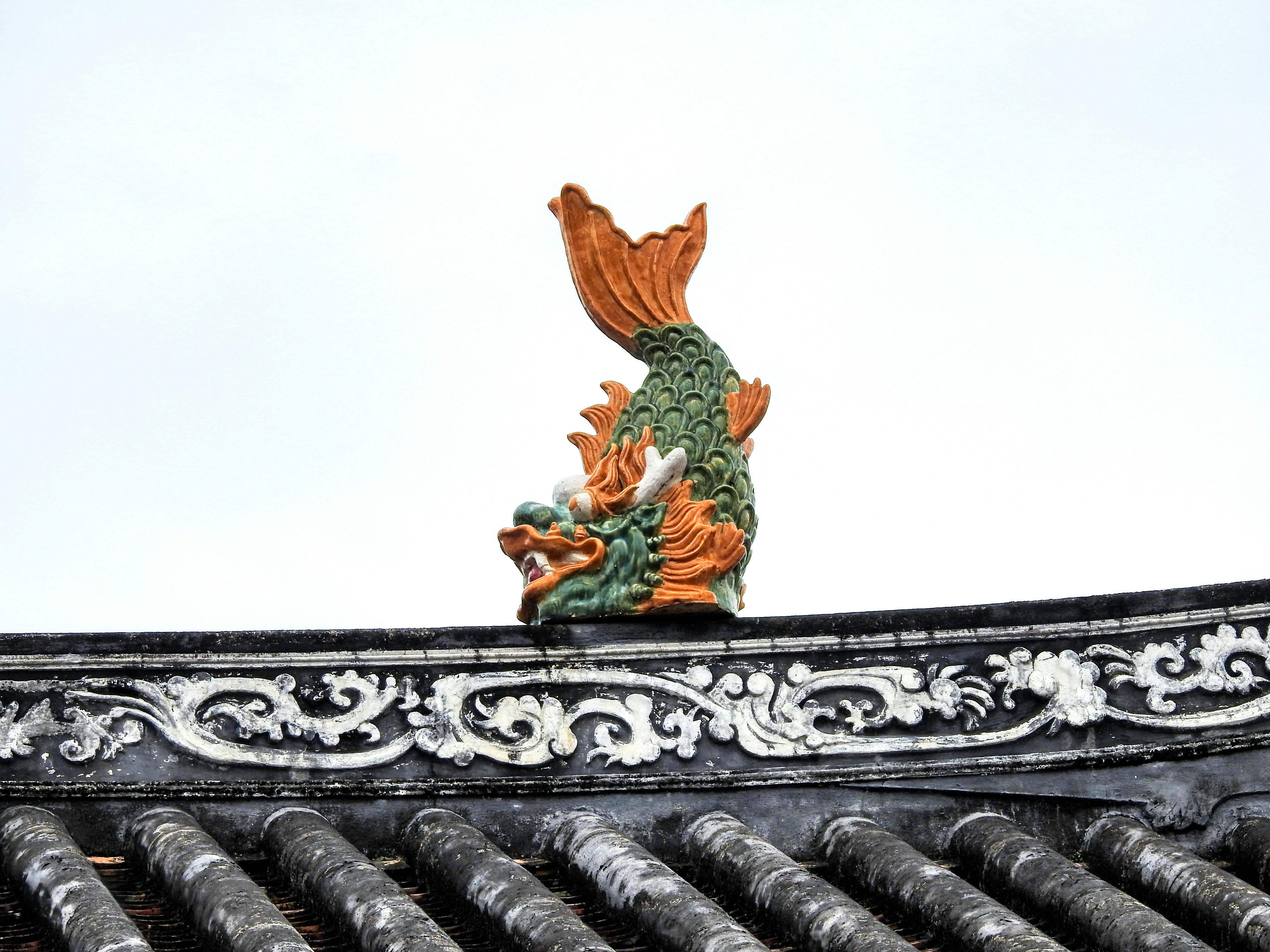 A statue of a fish on top of a roof