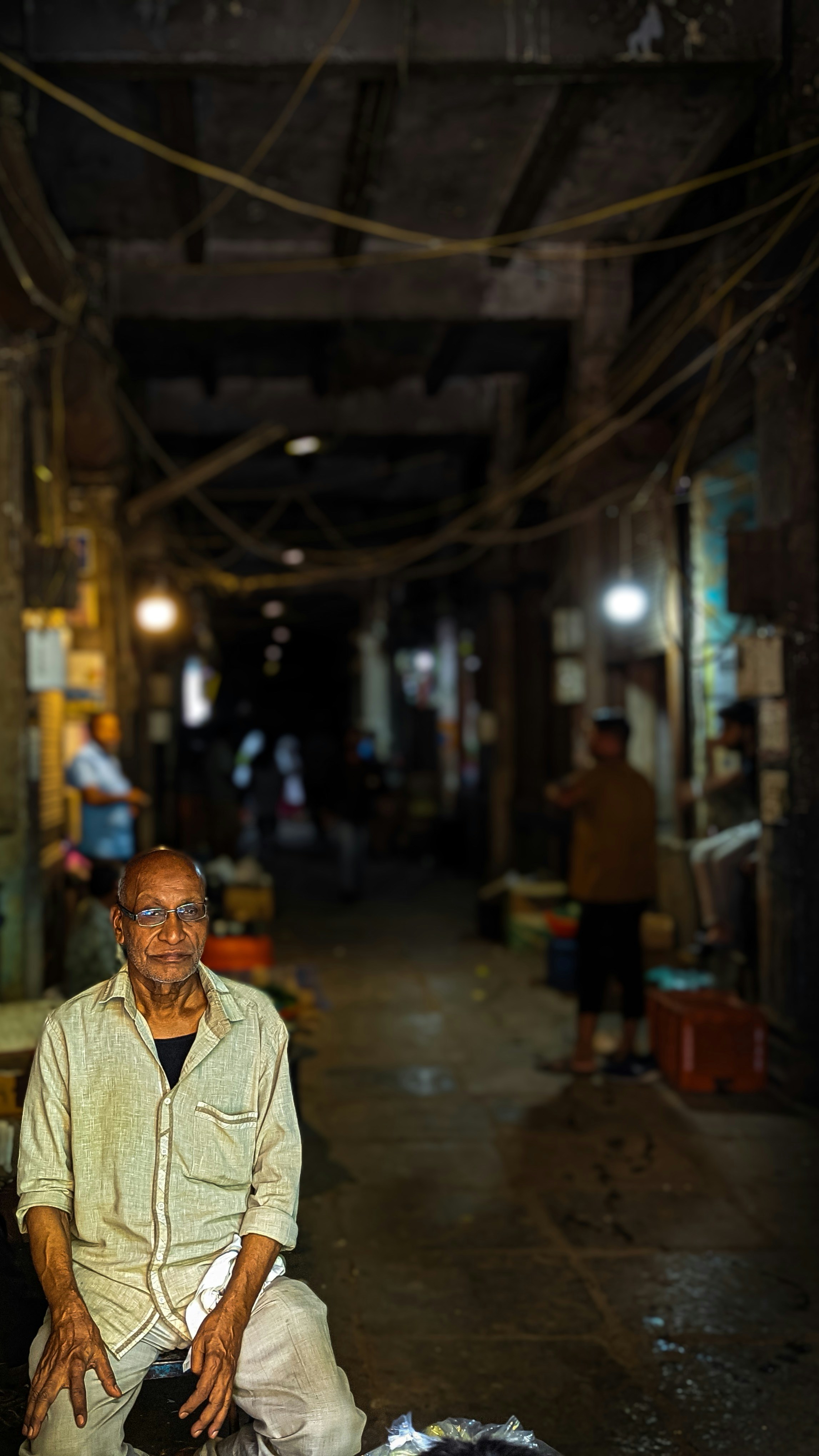 A man sitting on a pile of luggage in an alley